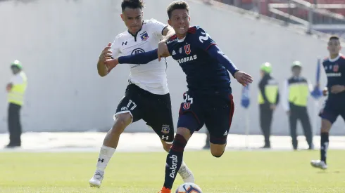 Pablo Parra disputa un balón con Gabriel Suazo en un Superclásico. Pronto será oficializado como incorporación de Colo Colo. 
