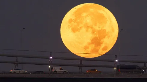 Estanbul, Turquía – 31 de agosto: Autos cruzan el Puente de los Mártires mientras la Super Luna Azul se pone detrás.
