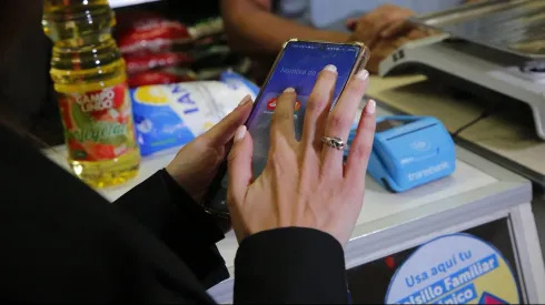 Una persona hace uso del Bolsillo Familiar Electrónico para pagar una compra en un almacén.
