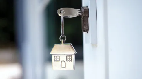 Llave abriendo la puerta de una casa.
