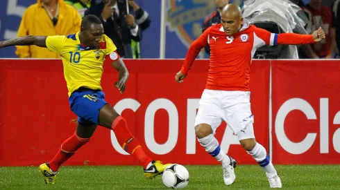 Walter Ayoví lucha con Humberto Suazo un balón en un duelo entre Chile y Ecuador. 
