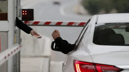 SConductor de un vehículo paga un peaje en la caseta de una autopista.
