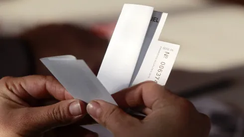 Persona doblando un voto.
