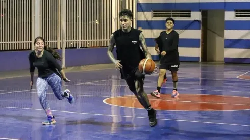 Erick Pulgar controlando el balón de básquetbol junto a su familia.
