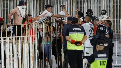 Arturo Vidal tratando de calmar a los "hinchas" de Colo Colo en el Estadio Nacional.
