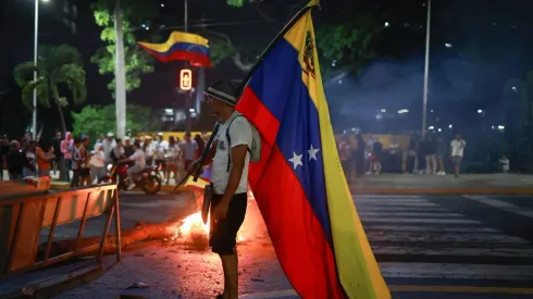 Caracas, Venezuela. Manifestante sostiene una bandera venezolana durante una protesta contra los resultados de las elecciones presidenciales.
