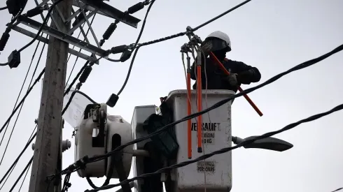 Funcionarios de Enel trabajan en la reposición de la luz en Peñalolén.
