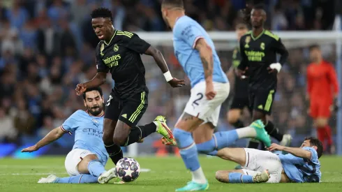 MANCHESTER, ENGLAND – MAY 17: Vinicius Junior of Real Madrid is challenged by Ilkay Guendogan of Manchester City during the UEFA Champions League semi-final second leg match between Manchester City FC and Real Madrid at Etihad Stadium on May 17, 2023 in Manchester, England. (Photo by Clive Brunskill/Getty Images)
