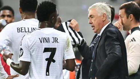 Vini Jr e Carlo Ancelotti conversam na beira do gramado.
