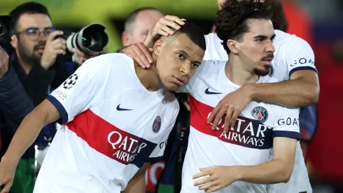 Kylian Mbappe of Paris Saint-Germain celebrates scoring his team's third goal from a penalty kick with teammate Vitinha during the UEFA Champions League quarter-final second leg match between FC Barcelona and Paris Saint-Germain at Estadi Olimpic Lluis Companys on April 16, 2024 in Barcelona, Spain.