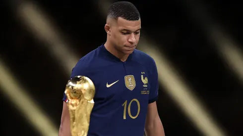 Kylian Mbappe of France walks past the FIFA World Cup trophy as he looks dejected following his team's loss in the final match against Argentina.