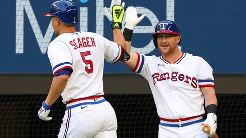 ARLINGTON, TEXAS - APRIL 30: Corey Seager #5 of the Texas Rangers is greeted by Kole Calhoun #56 after Seager hit a solo home run against the Atlanta Braves in the first inning at Globe Life Field on April 30, 2022 in Arlington, Texas. (Photo by Richard Rodriguez/Getty Images)