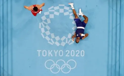 Abner Teixeira (ao centro, dir.) estendido no chão comemorando a vitória nas quartas de final do boxe masculino (Getty Images)