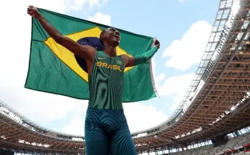 Alison dos Santos comemora a medalha de bronze com a bandeira do Brasil (Getty Images)
