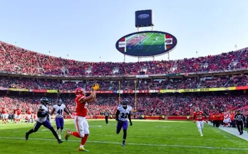 Travis Kelce (vermelho, a esq.) recebe um passe na endzone durante jogo entre Chiefs e Ravens, no Arrowhead Stadium (Getty Images)