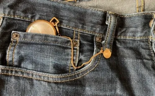 Um relógio de bolso no jeans. Créditos: Unsplash