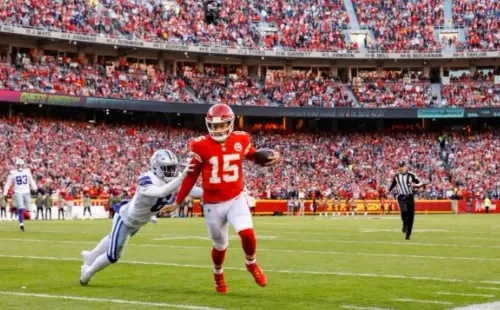 Patrick Mahomes #15 of the Kansas City Chiefs runs towards the sidelines in the first quarter, pursued by Donovan Wilson #6 of the Dallas Cowboys at Arrowhead Stadium on November 21, 2021 in Kansas City, Missouri. (Photo by David Eulitt/Getty Images)
