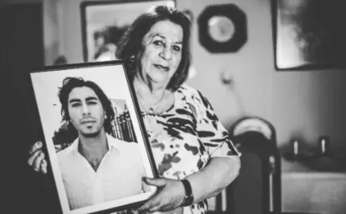 Gladys Muñoz junto a una foto de su hijo Johnny Herrera