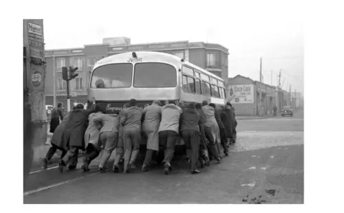 Una veintena de pasajeros empujan un bus de la locomoción colectiva en una calle de Santiago. Foto: Cedida.