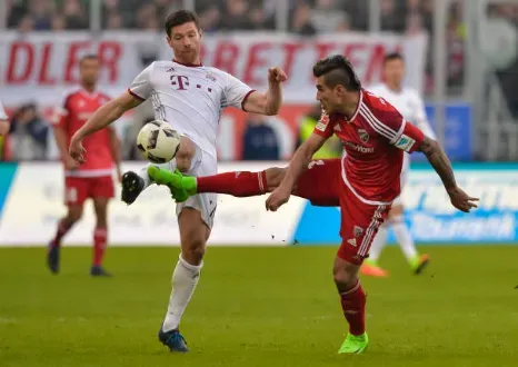 Darío Lezcano lucha ante Xabi Alonso del Bayern Múnich. (Getty Images).