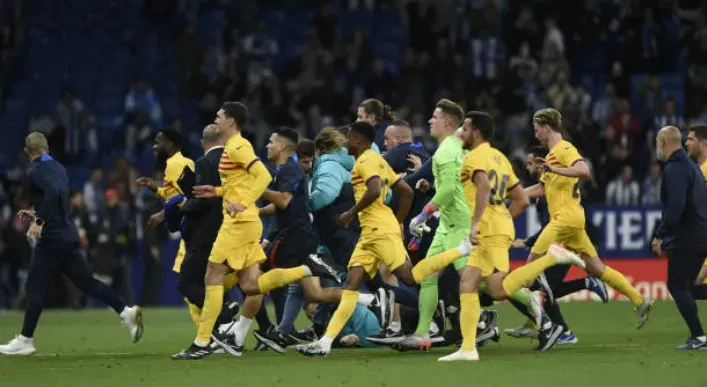 El momento en el que los jugadores del FC Barcelona debieron correr hacia el túnel por la invasión de los ultras de Espanyol al campo de juego. Getty Images.