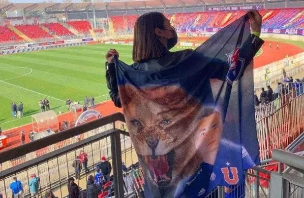 En el Superclásico en Talca con una bandera apoyando a su hermano. Foto: Instagram.