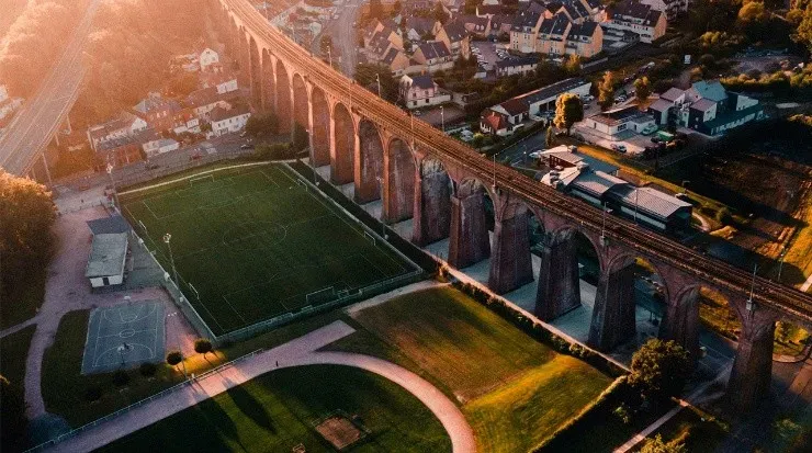 Apretada entre un puente ferroviario y una autopista brilla este césped (Fuente: Unsplash)