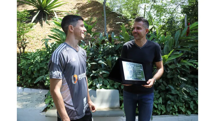 Foto: (Bruno Sousa/Atlético) - Nacho Fernández recebe a placa de 100 jogos pelo Atlético das mãos de Victor Bagy, gerente de futebol do Galo
