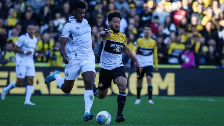  Arthur Caíke jogador do Criciúma disputa lance com Jemerson jogador do Grêmio durante partida no estádio Heriberto Hulse pelo campeonato Brasileiro A 2024. Foto: Leonardo Hübbe/AGIF
