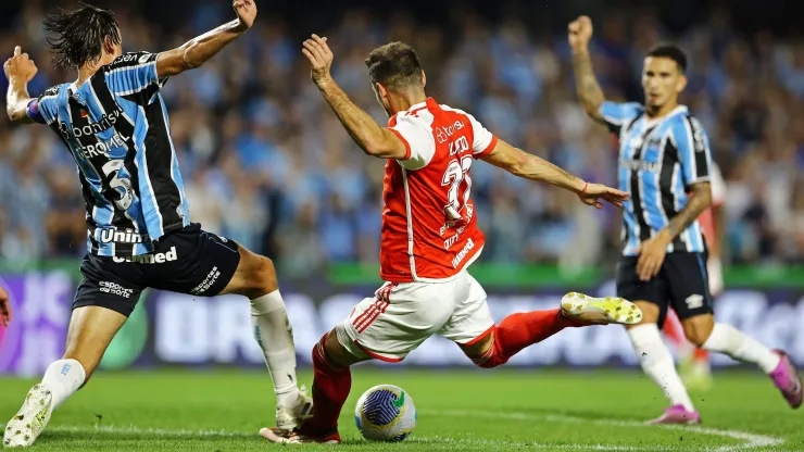 CURITIBA, BRAZIL - JUNE 22: Lucas Alario of Internacional tries to shoot past Pedro Geromel (L) of Gremio during the match between Gremio and Internacional as part of Brasileirao 2024 at Couto Pereira Stadium on June 22, 2024 in Curitiba, Brazil. (Photo by Heuler Andrey/Getty Images)
