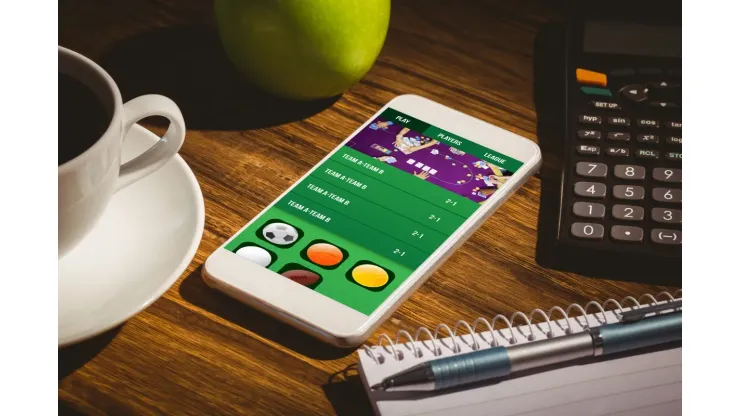 Gambling app screen against smartphone on table
