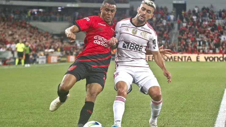 Erick jogador do Athletico-PR disputa lance com De Arrascaeta jogador do Flamengo durante partida no estadio Arena da Baixada pelo campeonato Copa do Brasil 2023. 
