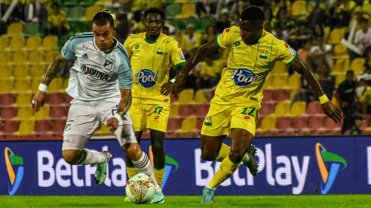 Leonardo Castro, de Millonarios, ante los jugadores de Atlético Bucaramanga.
