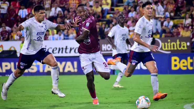 Brayan Gil disputa la pelota ante Emanuel Olivera y Nicolás Salazar en el último enfrentamiento entre Deportes Tolima y Junior.
