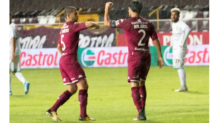 Saprissa's players celebrate a goal by touching elbows
