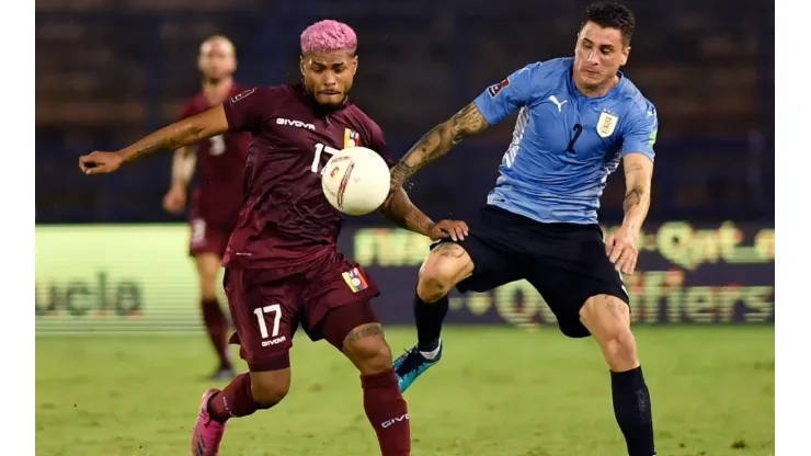 Josef Martínez of Venezuela fights for the ball with José Giménez of Uruguay
