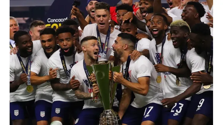 Paul Arriola #7 of United States and Sebastian Lletget #17 lifts the trophy to celebrate with his teammates after winning the CONCACAF Gold Cup 2021
