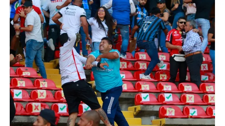 Fans of Atlas and Queretaro fight in the stands during the 9th round match between Queretaro and Atlas
