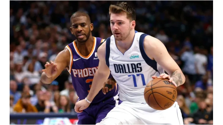 Luka Doncic of the Dallas Mavericks handles the ball as Chris Paul of the Phoenix Suns defends
