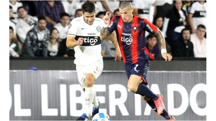 Ivan Torres of Olimpia competes for the ball with Alan Benitez of Cerro Porteño
