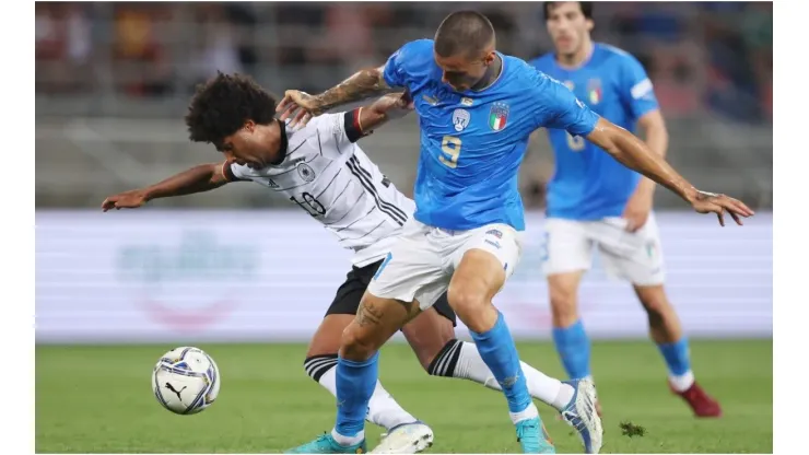 Serge Gnabry of Germany is challenged by Gianluca Scamacca of Italy
