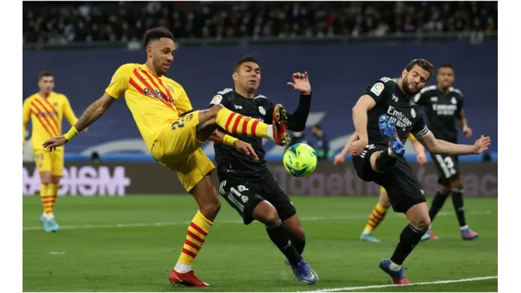 Pierre-Emerick Aubameyang of Barcelona battles for possession with Casemiro of Real Madrid
