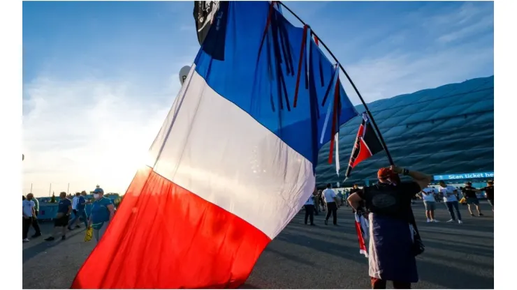 A man carrying a huge French flag
