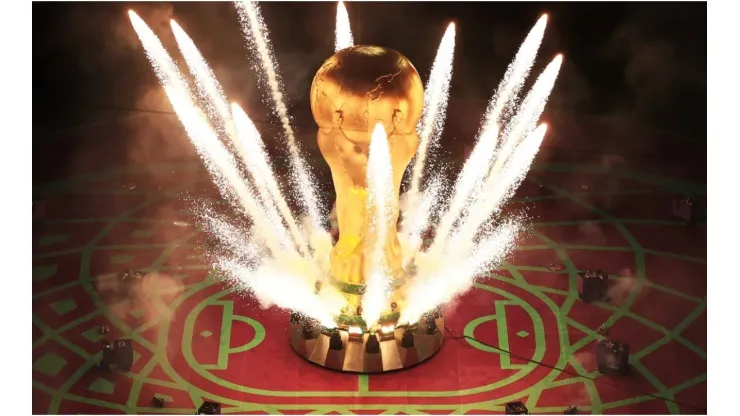 Pyrotechnics explode around a giant World Cup trophy
