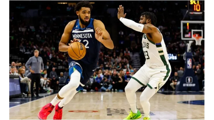 Karl-Anthony Towns of the Minnesota Timberwolves drives to the basket while Wesley Matthews of the Milwaukee Bucks
