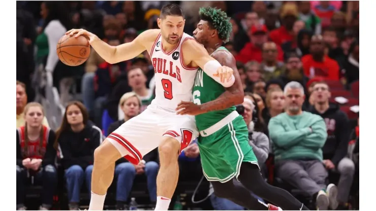 Nikola Vucevic of the Chicago Bulls drives to the basket against Marcus Smart of the Boston Celtics
