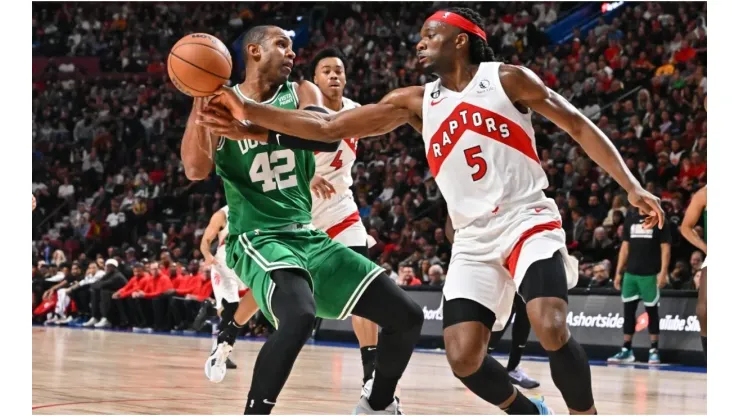 Al Horford of the Boston Celtics protects the ball from Precious Achiuwa of the Toronto Raptors
