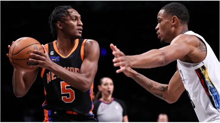 Immanuel Quickley #5 of the New York Knicks is guarded by Nicolas Claxton #33 of the Brooklyn Nets
