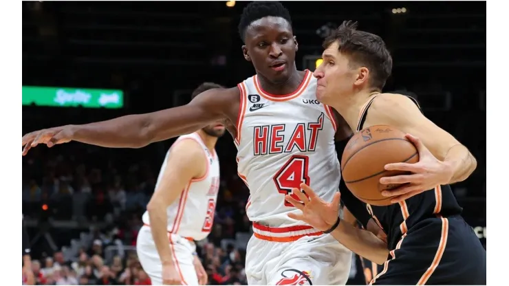 Bogdan Bogdanovic #13 of the Atlanta Hawks draws a foul from Victor Oladipo #4 of the Miami Heat
