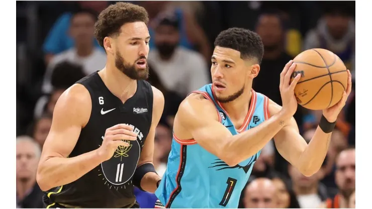 Devin Booker #1 of the Phoenix Suns handles the ball against Klay Thompson #11 of the Golden State Warriors
